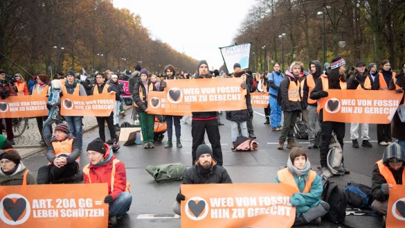 Aktivisten der Klimaschutzgruppe "Letzte Generation" und anderer Gruppierungen blockieren die Straße des 17. Juni in Berlin. - © Paul Zinken/dpa
