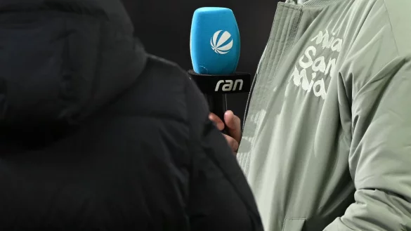 M&uuml;nchens Trainer h&auml;lt vor dem Spiel ein Mikrofon in der Hand. - &copy; Hendrik Schmidt/dpa/Symbolbild