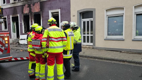 Feuerwehrleute stehen nach der Explosion in einem Mehrfamilienhaus vor dem zerst&ouml;rten Geb&auml;ude. - &copy; Markus Gayk/dpa