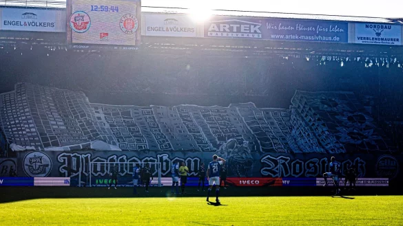 Hansa-Fans haben ein Banner mit H&auml;usern aus Rostock-Lichtenhagen &uuml;ber die Trib&uuml;ne gezogen. - &copy; Axel Heimken/dpa