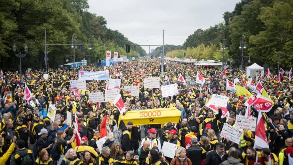 Postmitarbeiter stehen während einer Verdi-Großkundgebung zur Novelle des Postgesetzes auf der Straße des 17. Juni. - © Sebastian Christoph Gollnow/dpa