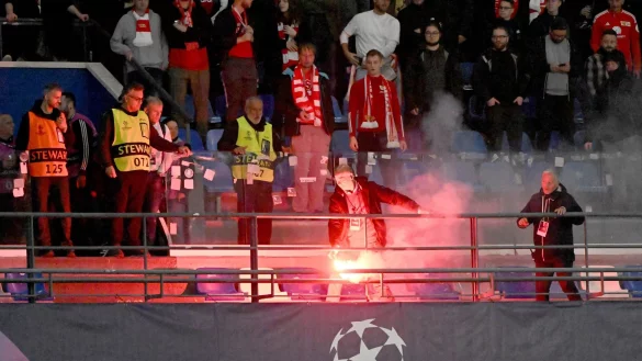 Ein Ordner entfernt eine Leuchtfackel aus dem G&auml;steblock, nachdem sie von Neapel-Fans dorthin geworfen war. - &copy; Matthias Koch/dpa