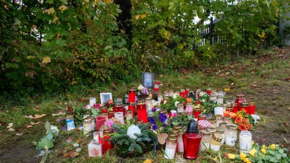 Kerzen und Blumen zum Gedenken: Ein Passant hatte den Toten auf einer Wiese in Horn-Bad Meinberg am Rande des Teutoburger Waldes entdeckt. - &copy; Sebastian Vogt/Stadt Horn-Bad Meinberg/dpa