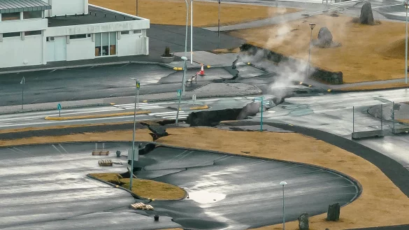 In der isländsichen Stadt Grindavik steigt Rauch aus Rissen im Boden. - © Bjorn Steinbekk/AP/dpa