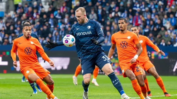 Wolfsburgs Aster Vranckx (l-r), Bochums Philipp Hofmann und Wolfsburgs Moritz Jenz k&auml;mpfen um den Ball. - &copy; David Inderlied/dpa
