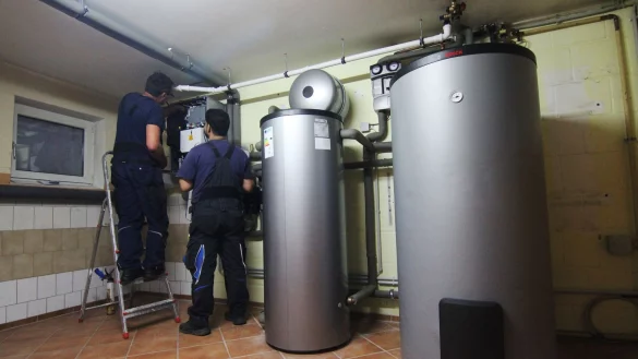 Zwei Handwerker stellen eine W&auml;rmepumpe im Keller einer Doppelhaush&auml;lfte ein. - &copy; Doreen Garud/dpa