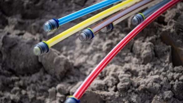 Glasfaserkabel auf einer Baustelle: Beim umstrittenen Doppelausbau von sehr schnellem Glasfaser-Internet sind schon Hunderte Wortmeldungen bei der Bundesnetzagentur eingegangen. - © Sina Schuldt/dpa