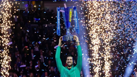 Novak Djokovic jubelt mit seiner Troph&auml;e nach seinem Sieg. - &copy; Antonio Calanni/AP/dpa