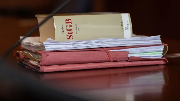 Das Strafgesetzbuch und Akten liegen in einem Gericht auf dem Tisch. - © Swen Pförtner/dpa/Symbolbild