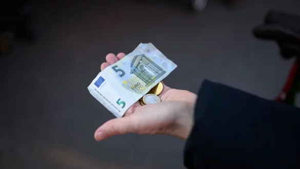 Eine Frau h&auml;lt das Bargeld f&uuml;r ihren Einkauf in der Hand bereit. - &copy; Jonas Walzberg/dpa/Symbolbild