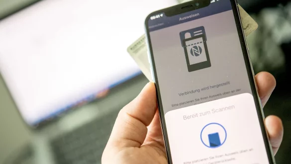 Online ausweisen ist nicht schwer: Fordert die &laquo;Ausweisapp2&raquo; dazu auf, h&auml;lt man seinen Ausweis zum Scannen unters Smartphone und gibt seine PIN ein. - &copy; Zacharie Scheurer/dpa-tmn