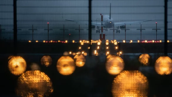 Ein Flugzeug landet hinter Signallichtern auf einem Flughafen. - &copy; Sebastian Gollnow/dpa/Symbolbild