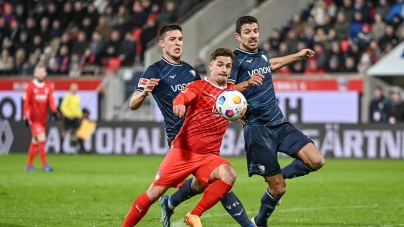 Bochums Keven Schlotterbeck (l) und Bochums Anthony Losilla (r) in Aktion gegen Heidenheims Nikola Dovedan (M). - &copy; Harry Langer/dpa
