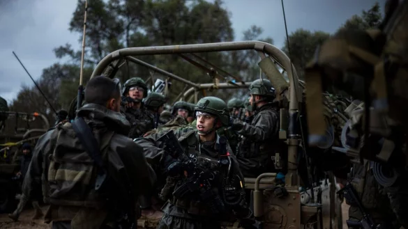 Israelische Soldaten sitzen in einem Milit&auml;rfahrzeug an einem Sammlepunkt nahe der Grenze zum Gazastreifen. - &copy; Ilia Yefimovich/dpa