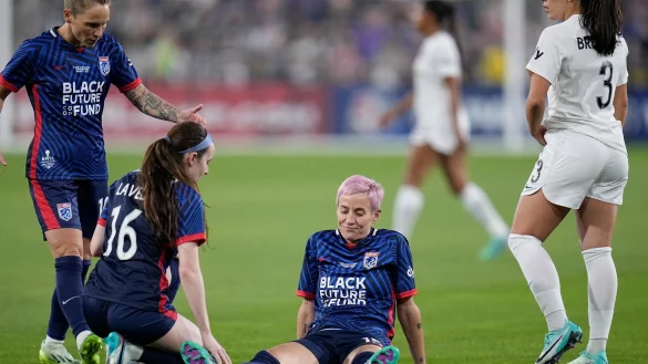 Megan Rapinoe (M) bleibt nach einer Verletzung auf dem Rasen liegen. - &copy; Gregory Bull/AP