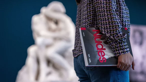 Eine Besucherin steht an einer Marmorstatue und h&auml;lt dabei das Ausstellungsbuch in der Hand. - &copy; Guido Kirchner/dpa