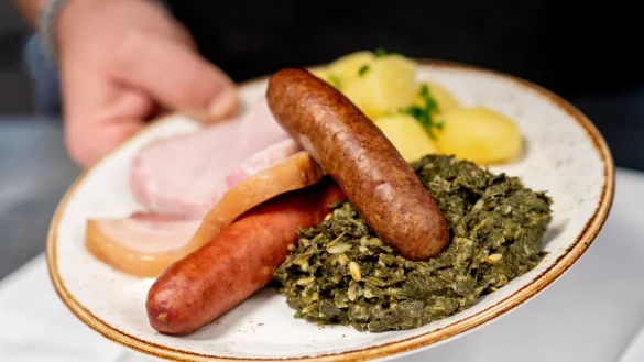Saftig und deftig: Eine Portion Gr&uuml;nkohl mit den traditionellen Beilagen Salzkartoffeln, Kochwurst, Pinkelwurst und Kasseler - serviert in einem Oldenburger Restaurant. - &copy; Hauke-Christian Dittrich/dpa/dpa-tmn