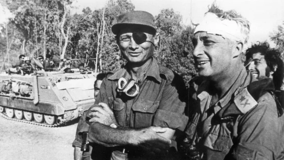 Der damalige israelische Verteidigungsminister und General Mosche Dajan (l.) mit dem damaligen Generalmajor Ariel Scharon, der einen Kopfverband tr&auml;gt, aufgenommen im Oktober 1973 auf der &auml;gyptischen Seite des Suezkanals w&auml;hrend des 4. israelisch-arabischen Krieges. - &copy; UPI/dpa