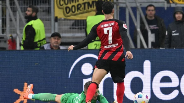 Frankfurts Omar Marmoush (r) wird von Dortmunds Torwart Alexander Meyer attackiert. - &copy; Arne Dedert/dpa