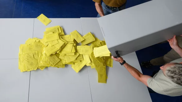 Stimmzettelumschläge für eine Briefwahl werden aus einer Wahlurne geschüttet. - © Robert Michael/dpa/Symbolbild