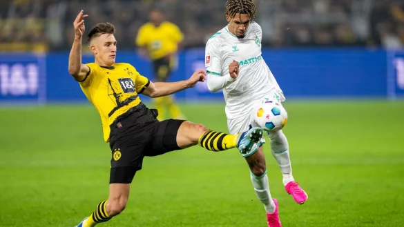 Dortmunds Nico Schlotterbeck (l.) und Bremens Justin Njinmah k&auml;mpfen um den Ball. - &copy; David Inderlied/dpa