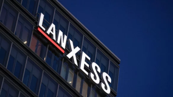 Das Logo leuchtet am Abend an der Hauptverwaltung des Chemie Konzerns Lanxess. - © Oliver Berg/dpa/Archivbild