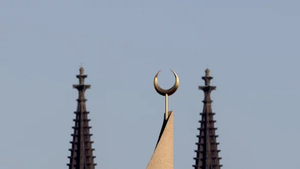 Ein Halbmond auf einer Moschee ist zwischen den T&uuml;rmen des K&ouml;lner Doms zu sehen. - &copy; Rolf Vennenbernd/dpa