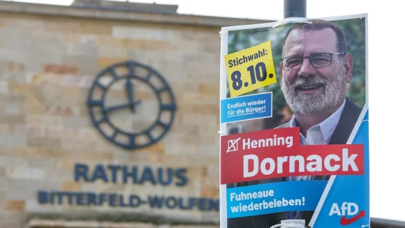 Ein Wahlplakat des AfD-Kandidaten Henning Dornack hängt vor dem Rathaus von Bitterfeld-Wolfen. - © Jan Woitas/dpa