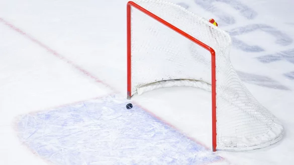 Ein Puck fliegt in ein leeres Eishockey-Tor. - &copy; Uwe Anspach/Deutsche Presse-Agentur GmbH/dpa/Symbolbild