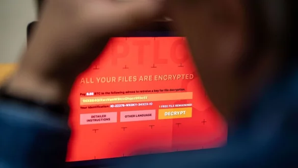 Ein Mann sitzt vor einem Laptop, der mit einem fiktiven Verschlüsselungstrojaner (Ransomware) befallen ist. - © Lino Mirgeler/dpa