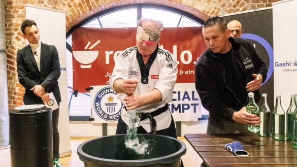 Der Kampfsportler Muhamed Kahrimanovic beim Versuch, mit verbundenen Augen und einem rohen Ei in der Hand Glasflaschen zu zerschlagen. - &copy; Markus Scholz/dpa