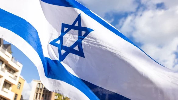 Eine israelische Flagge weht w&auml;hrend der Kundgebung &laquo;Aufstehen gegen Israelhass und Antisemitismus&raquo; in K&ouml;ln. - &copy; Thomas Banneyer/dpa