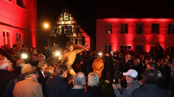 Zahlreiche Menschen umringen die frisch enthüllte Gerd-Müller-Statue in Nördlingen. - © Karl-Josef Hildenbrand/dpa