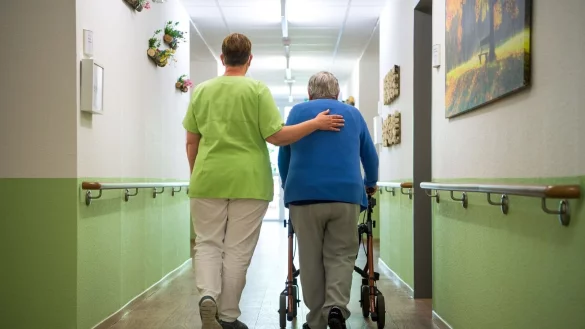 Eine Pflegefachkraft geht mit einer Bewohnerin durch ein Seniorenheim im nieders&auml;chsischen Nienburg. - &copy; Sina Schuldt/dpa