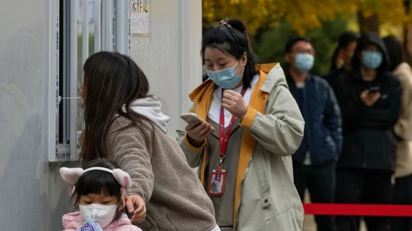 Anwohner an einer Coronavirus-Teststelle in Peking. - © Andy Wong/AP/dpa