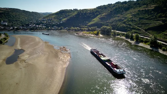 Ein Frachtschiff passiert im Juli 2022 auf dem Rhein eine Sandbank. - &copy; Thomas Frey/dpa