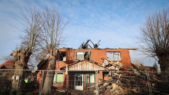 Ein Zaun der Landespolizei Schleswig-Holstein sichert das abgebrannte Haus, in dem zwei junge Menschen ums leben kamen. - &copy; Christian Charisius/dpa