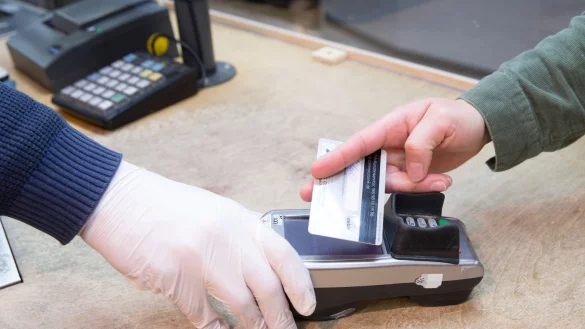 Ein Verkäufer hält einem Kunden das EC-Lesegerät zum kontaktlosen Bezahlen hin. - © Georg Wenzel/dpa-Zentralbild/dpa