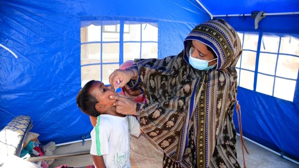 Nach den schweren &Uuml;berschwemmungen in Pakistan verabreicht eine Mitarbeiterin des Gesundheitswesen einem Kind eine Schluckimpfung gegen Polio. - &copy; Pervez Masih/AP/dpa