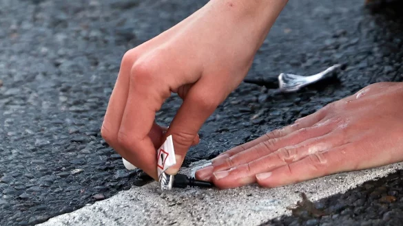 Ein Demonstrant klebt seine Hand in Berlin mit Sekundenkleber auf der Stra&szlig;e fest. - &copy; Carsten Koall/dpa