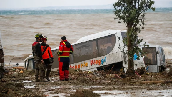 Rettungskr&auml;fte auf Ischia neben einem Bus, der durch schwere Regenf&auml;lle weggeschwemmt wurde. - &copy; Salvatore Laporta/AP/dpa