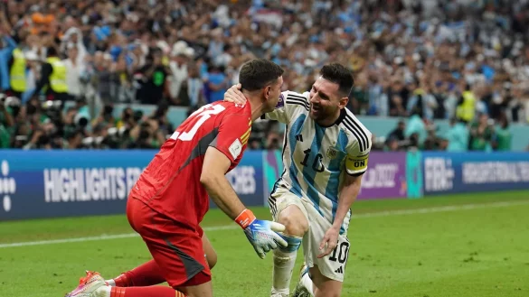 Mann des Abends: Lionel Messi (r) feiert Elmeterkiller Emiliano Martinez. - &copy; Martin Rickett/PA Wire/dpa