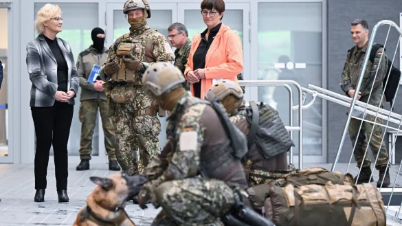 Bundesverteidigungsministerin Christine Lambrecht (l, SPD) sieht sich bei ihrem Besuch beim Kommando Spezialkr&auml;fte (KSK) in einer Schwimmhalle eine Ausbildungs&uuml;bung mit einem Hund an. - &copy; Bernd Wei&szlig;brod/dpa