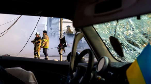 Feuerwehrleute sind an einer Einschlagstelle im Zentrum von Kiew im Einsatz. - © Roman Hrytsyna/AP/dpa