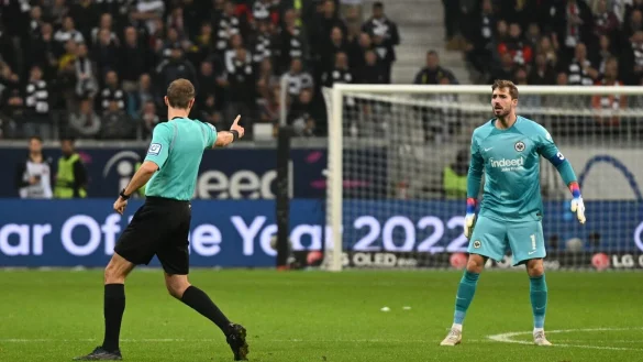 Schiedsrichter Sascha Stegemann (l) verwarnt Frankfurts Torwart Kevin Trapp. - &copy; Arne Dedert/dpa