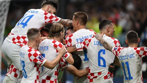 Die kroatischen Spieler feiern ihren Torhüter Dominik Livakovic. - © Robert Michael/dpa