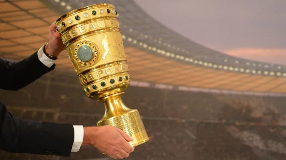 Ein Mann nimmt den DFB-Pokal von seinem Sockel. - © picture alliance / dpa