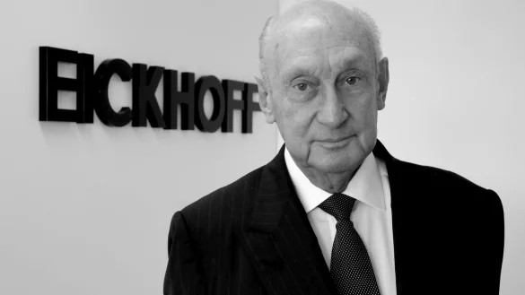 Der Mode-Einzelhändler Albert Eickhoff steht vor dem Firmenlogo in seinem Büro. - © picture alliance / dpa / Archivbild