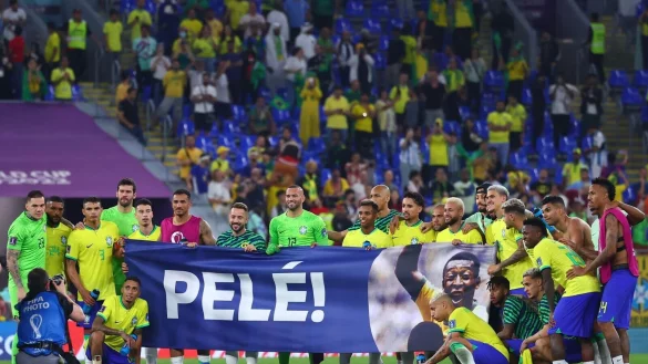 Die Spieler Brasiliens halten ein Poster mit Genesungsw&uuml;nschen f&uuml;r Fu&szlig;ballikone Pel&eacute; nach dem Abpfiff. - &copy; Tom Weller/dpa