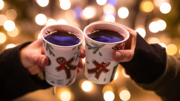 Zwei Besucherinnen eines Weihnachtsmarktes sto&szlig;en mit Gl&uuml;hwein an. - &copy; Christoph Schmidt/dpa/Symbolbild